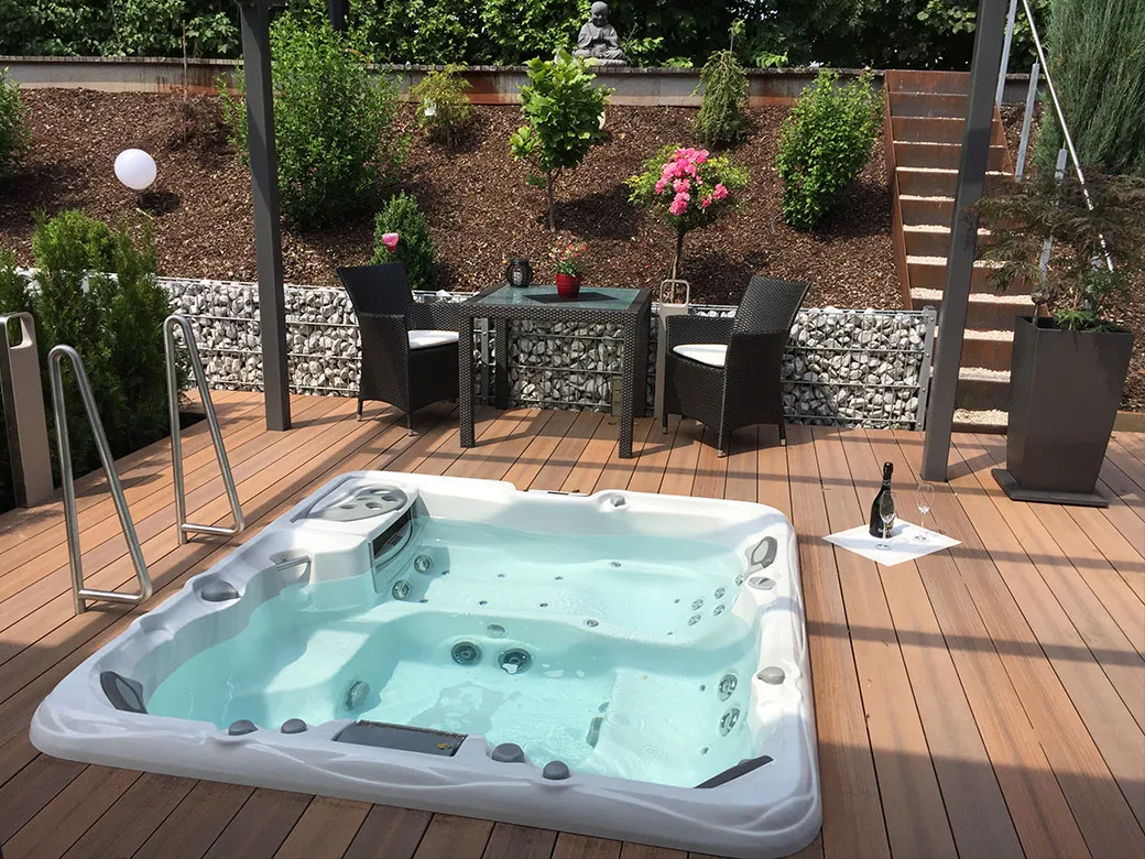 Whirlpool Altamar elegant in die Terrasse eingelassen – moderner Außenbereich mit gemütlicher Sitzlounge und Gartengestaltung.
