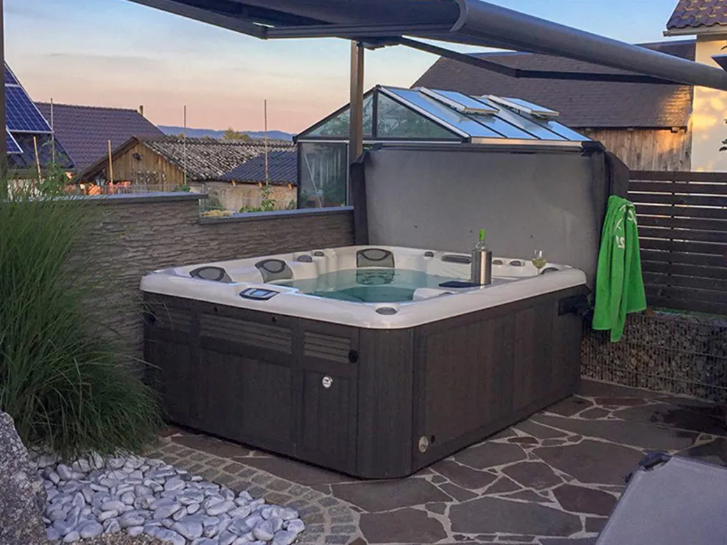 Whirlpool Marin in geschützter Terrassenecke mit teilüberdachter Konstruktion, ideal für entspannte Abende im Freien.
